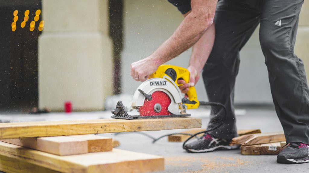 Handyman, super, or property manager cutting wood with a saw for repairs/maintenance