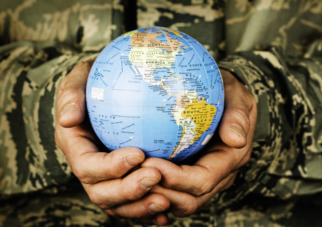 American soldier holding small globe with focus on USA