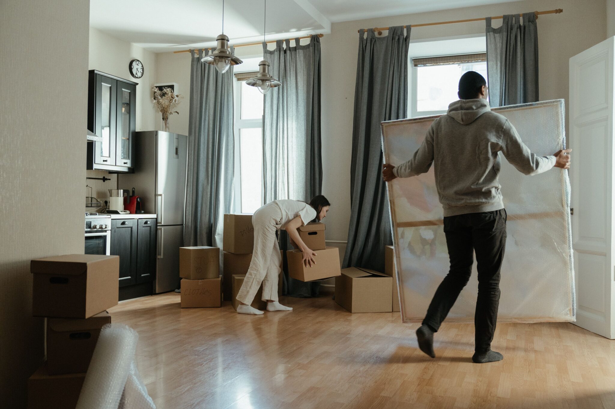 Couple moving boxes into their new home.