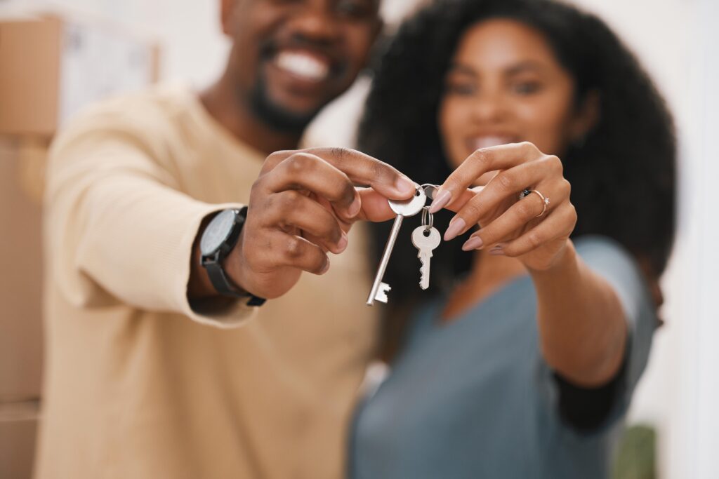 Couple holding two different house keys.